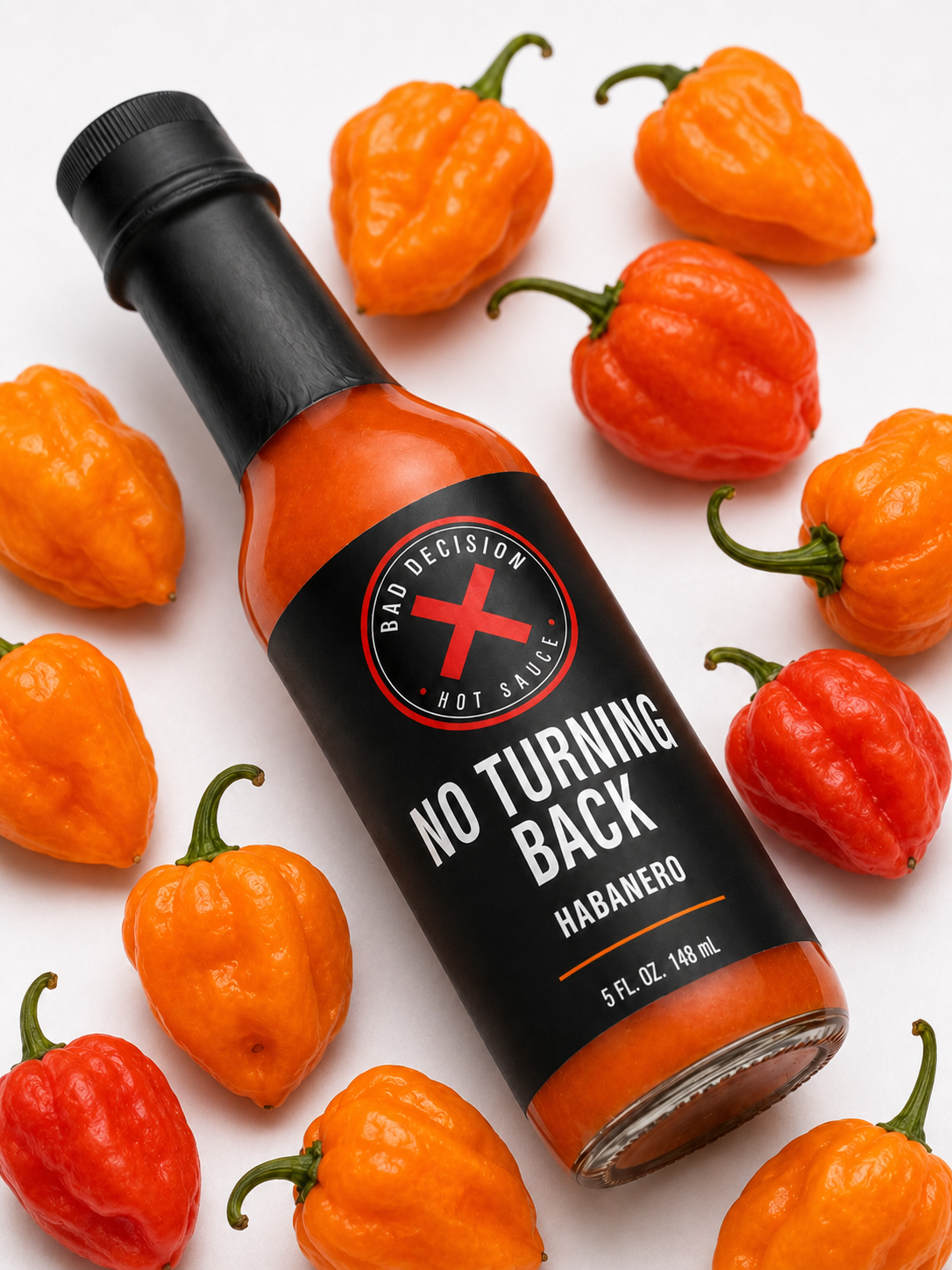 No Turning Back habanero hot sauce bottle lying among fresh habanero peppers