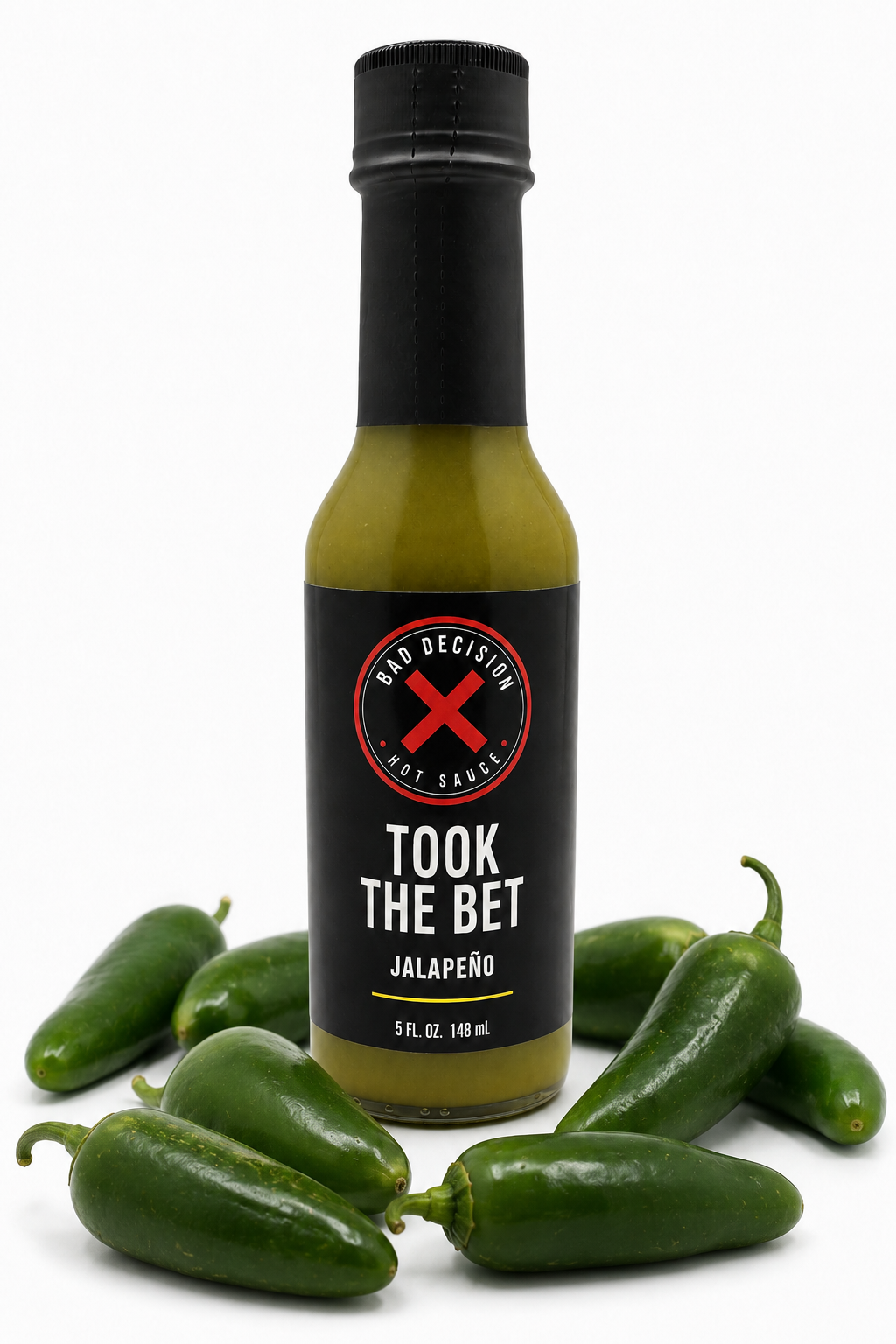Took The Bet jalapeño hot sauce bottle surrounded by fresh jalapeño peppers